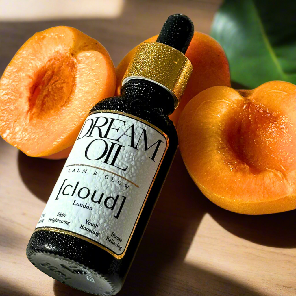 Dream Oil laying next to three slices of cut apricot.