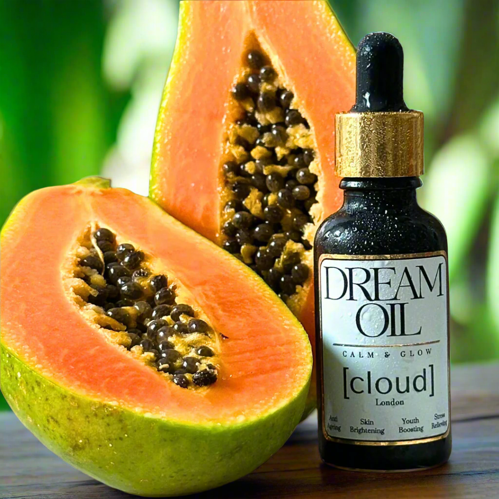 Dream Oil next to two slices of papaya fruit.